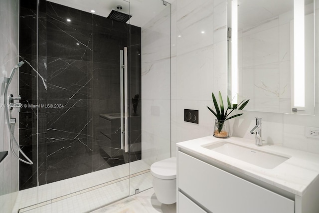 bathroom featuring vanity, toilet, tiled shower, and tile walls