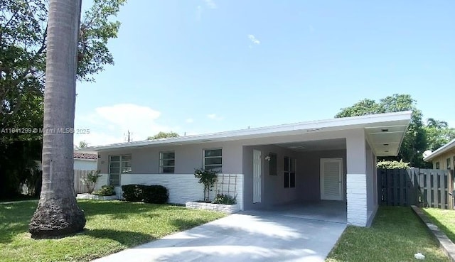 1005 NE 2nd St, Hallandale Beach, FL 33009 - ranch-style home featuring concrete driveway, a front lawn, a carport, fence, and stucco siding