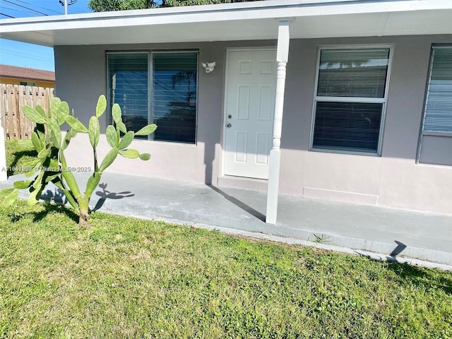 property entrance with a lawn