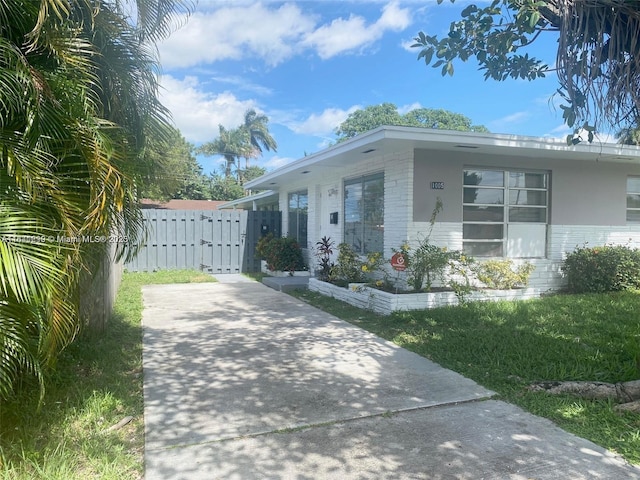 1005 NE 2nd St, Hallandale Beach, FL 33009 - view of home's exterior featuring brick siding, fence, and a yard