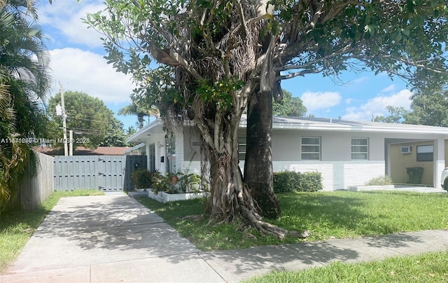 1005 NE 2nd St, Hallandale Beach, FL 33009 - view of front of property featuring fence, driveway, a front lawn, and brick siding