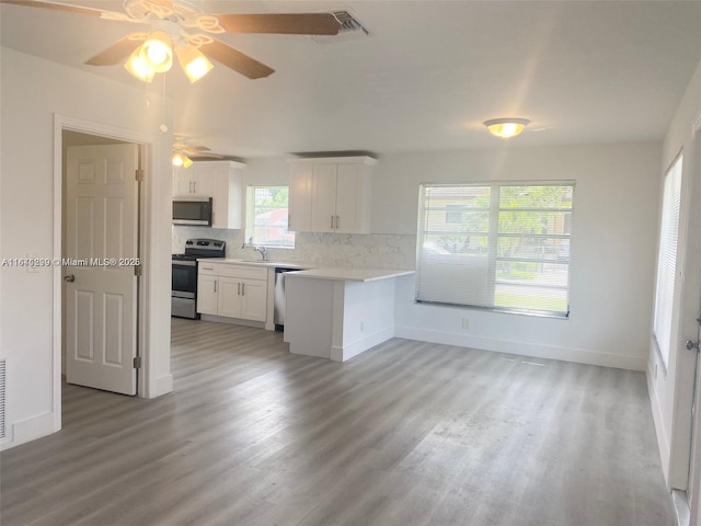 kitchen featuring backsplash, light hardwood / wood-style floors, white cabinetry, and stainless steel appliances