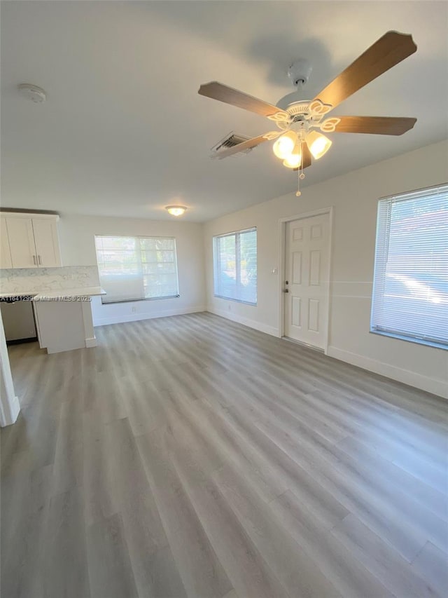 unfurnished living room featuring ceiling fan, a healthy amount of sunlight, and light hardwood / wood-style flooring