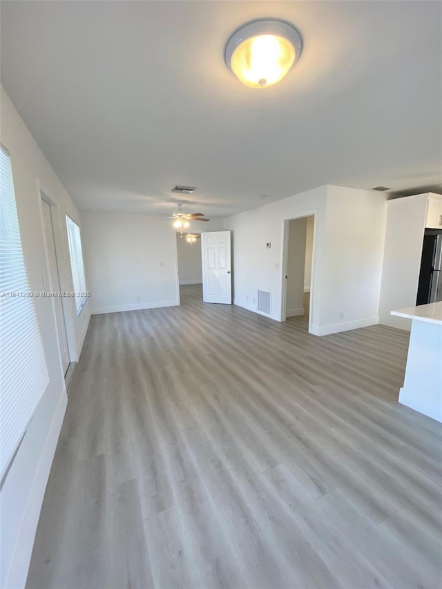 1005 NE 2nd St, Hallandale Beach, FL 33009 - unfurnished living room with baseboards, light wood-style flooring, and visible vents
