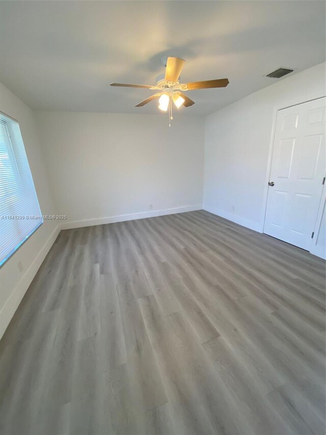 1005 NE 2nd St, Hallandale Beach, FL 33009 - unfurnished bedroom featuring baseboards, wood finished floors, visible vents, and ceiling fan