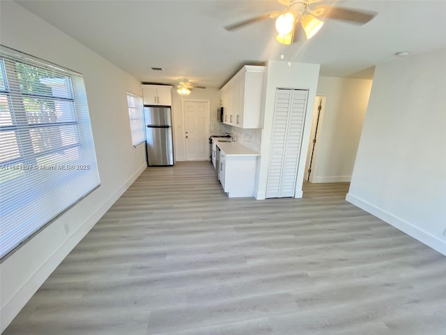 1005 NE 2nd St, Hallandale Beach, FL 33009 - kitchen featuring ceiling fan, range, light wood finished floors, white cabinets, and freestanding refrigerator