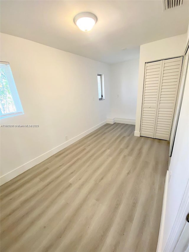 unfurnished bedroom with a closet and light hardwood / wood-style floors