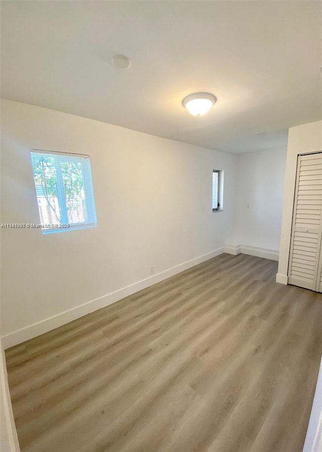 unfurnished bedroom with hardwood / wood-style flooring and a closet