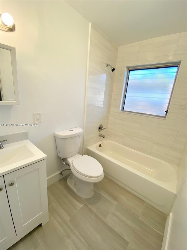 full bathroom featuring tiled shower / bath combo, toilet, and vanity