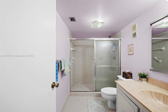 bathroom with vanity, toilet, tile patterned flooring, and a shower with shower door