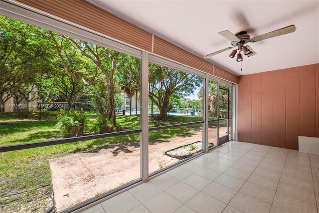 unfurnished sunroom with ceiling fan