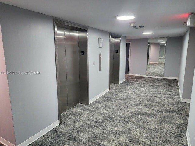 corridor featuring elevator and carpet