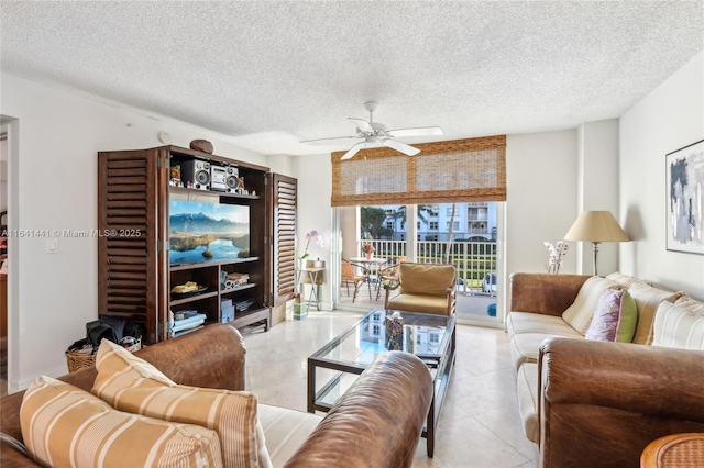 living room featuring light tile patterned floors, ceiling fan, and a textured ceiling