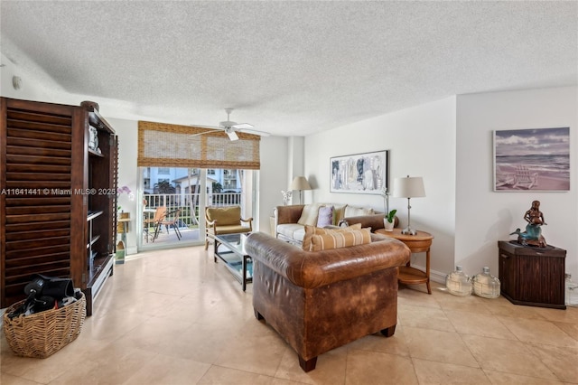 living area with light tile patterned floors, ceiling fan, and a textured ceiling