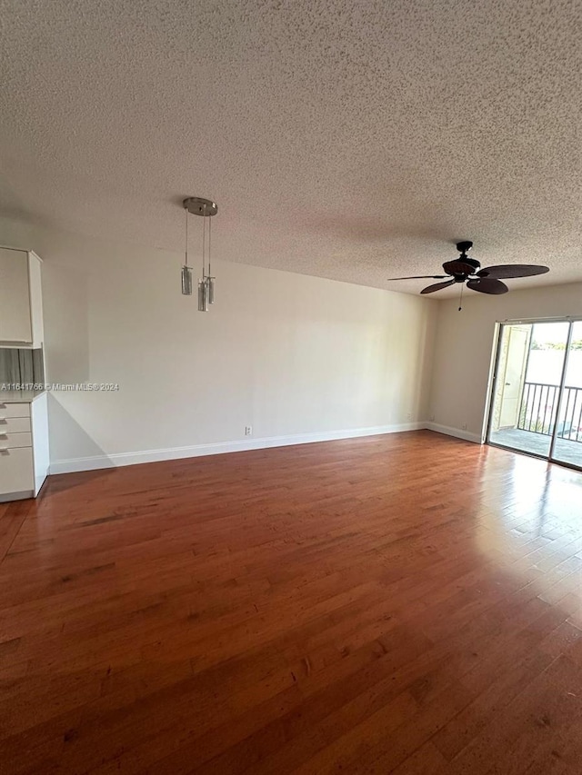 empty room with a textured ceiling, ceiling fan, and hardwood / wood-style floors