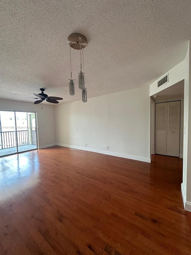 unfurnished room featuring a textured ceiling, ceiling fan, and dark hardwood / wood-style flooring