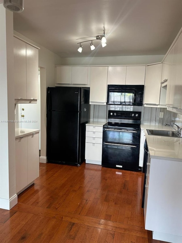 kitchen with black appliances, sink, white cabinetry, and dark wood-type flooring