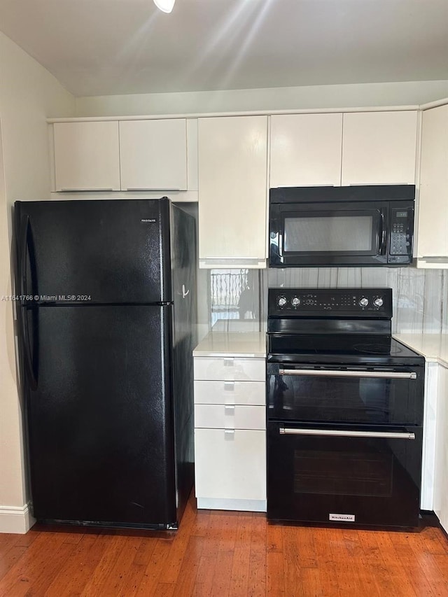 kitchen featuring light wood-type flooring, black appliances, and white cabinets