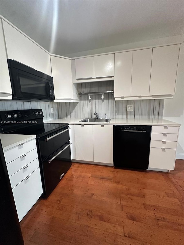 kitchen featuring black appliances, dark hardwood / wood-style floors, white cabinetry, and sink