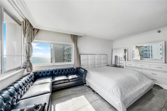 bedroom with a water view, light wood-type flooring, and ornamental molding