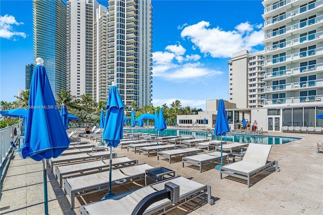 community pool with a city view and a patio