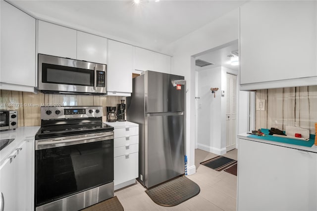 kitchen featuring appliances with stainless steel finishes, backsplash, and white cabinetry