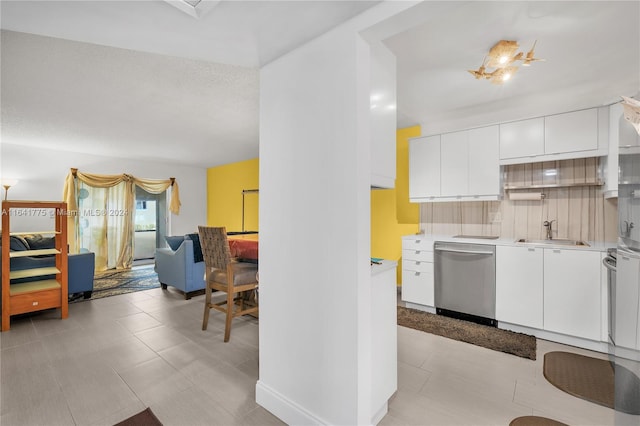 kitchen with light tile patterned flooring, white cabinets, sink, and dishwasher