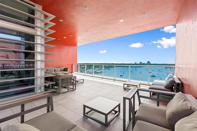 balcony with a water view, an outdoor hangout area, and a view of the beach