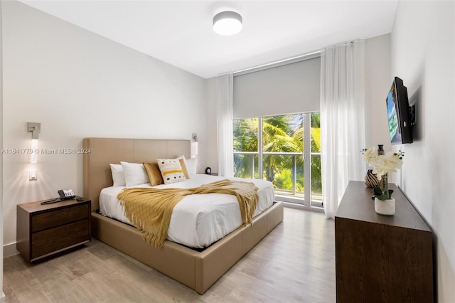 bedroom with access to exterior and light hardwood / wood-style flooring