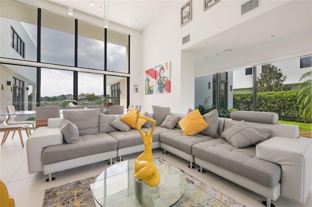 living room featuring tile patterned floors, floor to ceiling windows, and a high ceiling