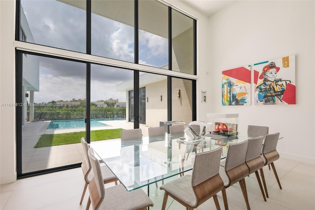 tiled dining room with a high ceiling and expansive windows