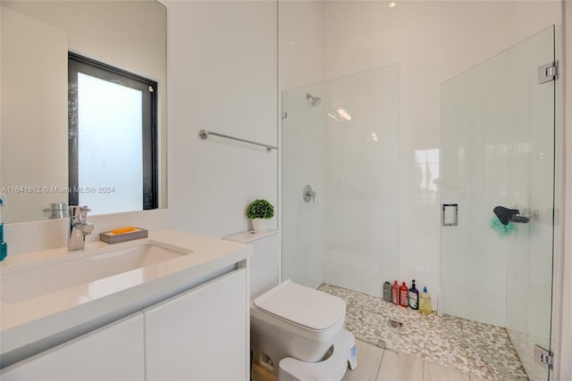 bathroom with toilet, vanity, and a shower with shower door