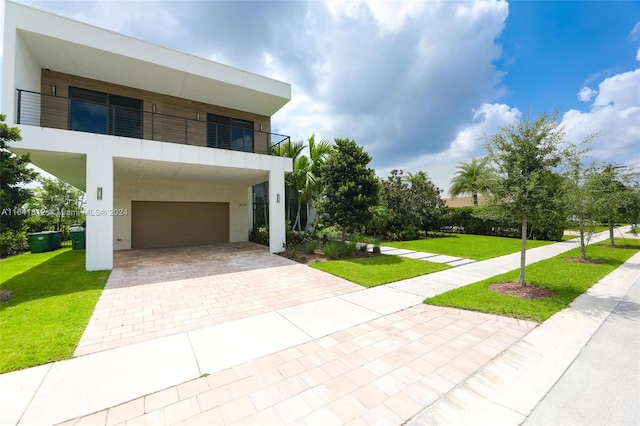 view of front facade with a front lawn and a balcony