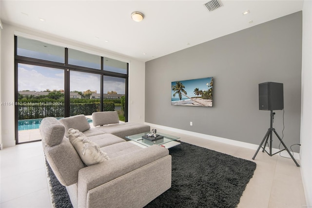 living room with light tile patterned flooring and floor to ceiling windows