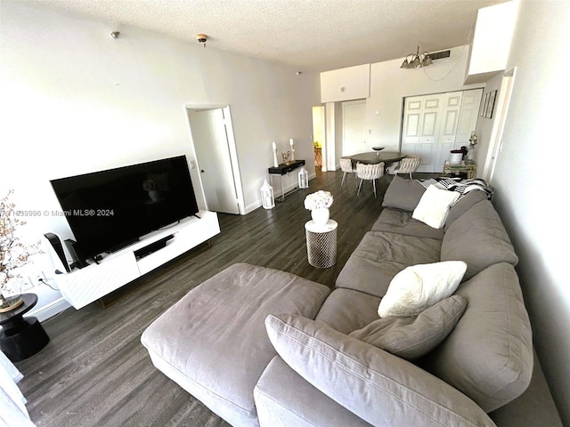 living area with baseboards, a textured ceiling, and wood finished floors