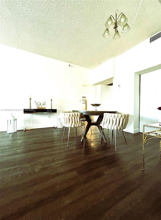 dining area featuring visible vents, a textured ceiling, baseboards, and wood finished floors