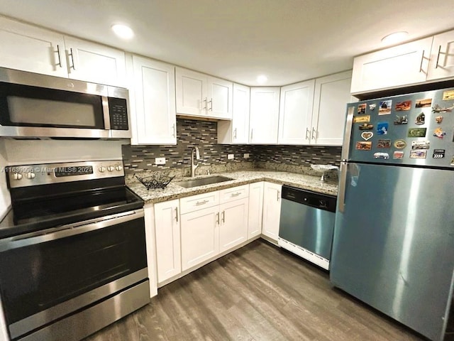 kitchen featuring tasteful backsplash, dark wood-style flooring, stainless steel appliances, white cabinetry, and a sink