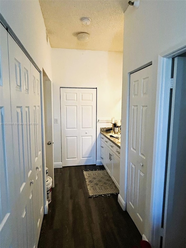 interior space with a textured ceiling and dark wood-style flooring