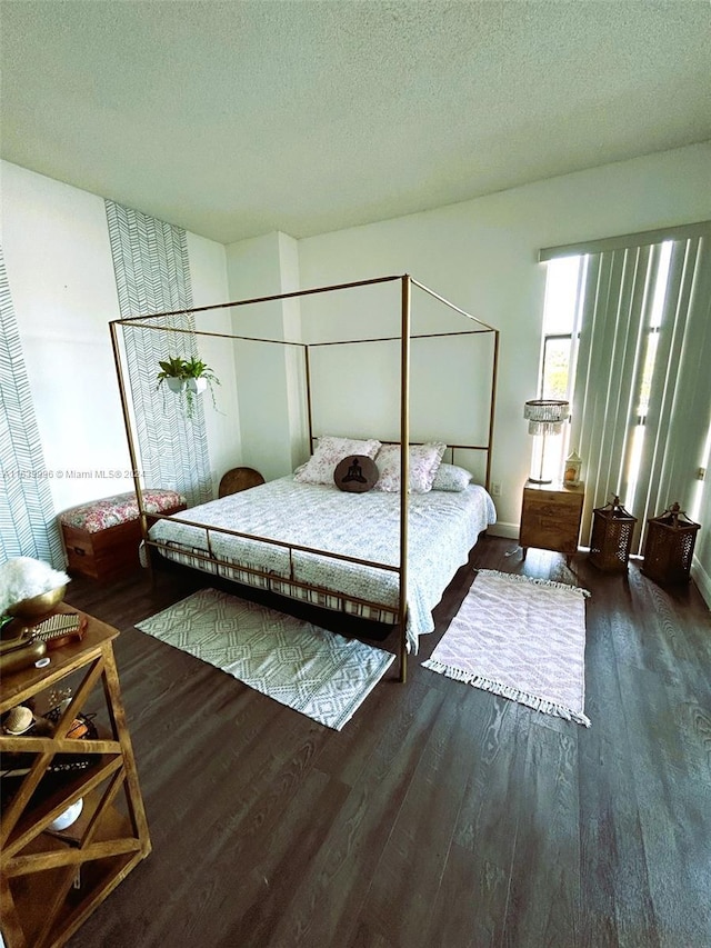 bedroom with a textured ceiling and wood finished floors