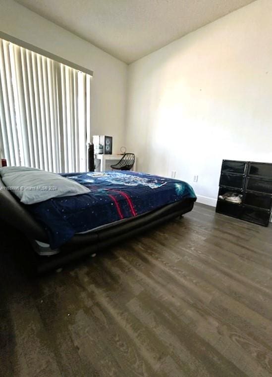 bedroom featuring baseboards and wood finished floors