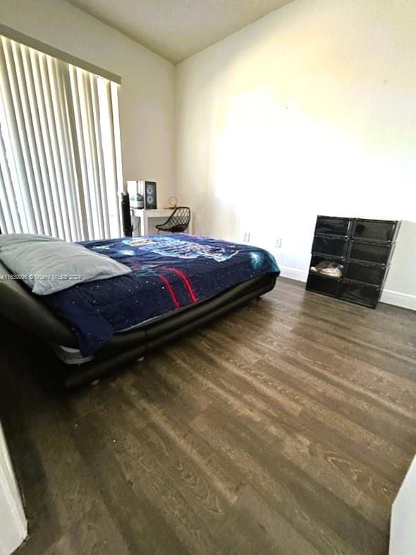 bedroom featuring wood finished floors and baseboards