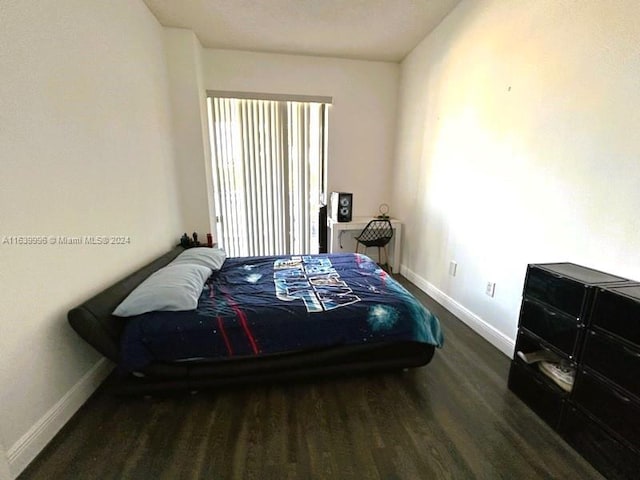 bedroom with wood finished floors and baseboards