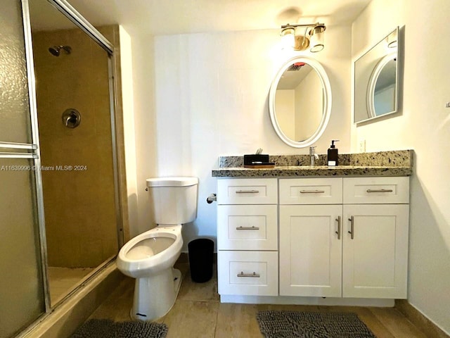 bathroom with toilet, a shower stall, and vanity