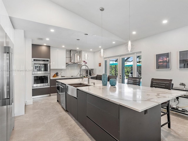 kitchen with french doors, stainless steel double oven, white cabinets, wall chimney range hood, and modern cabinets