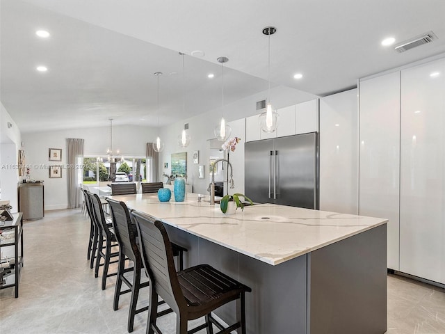 kitchen with built in refrigerator, modern cabinets, visible vents, and white cabinets