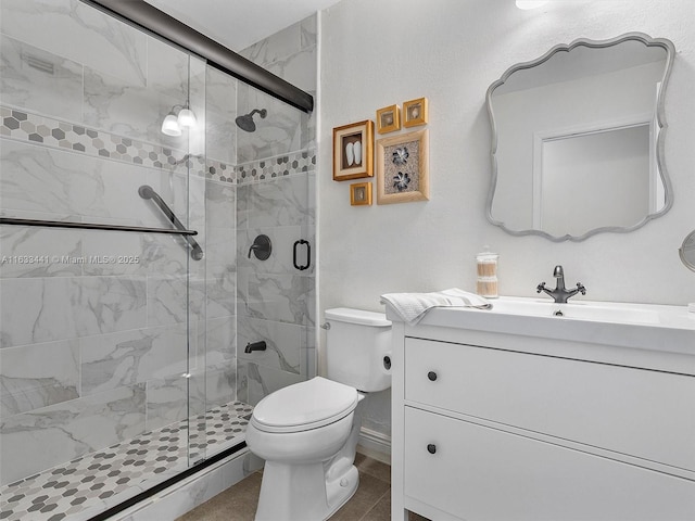 bathroom featuring vanity, a shower stall, and toilet