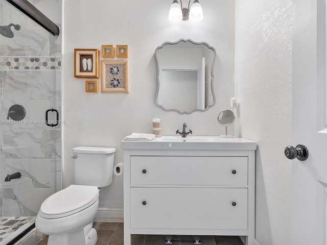 bathroom with baseboards, a shower stall, toilet, and vanity