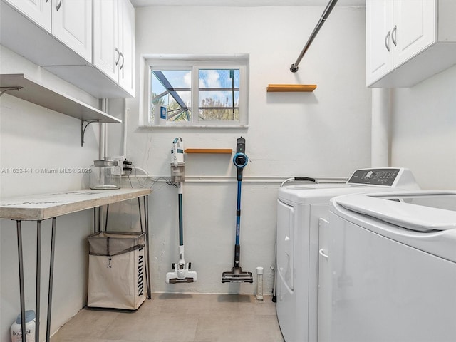 clothes washing area featuring cabinet space and independent washer and dryer