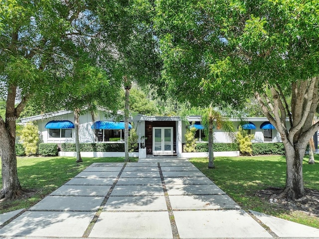 exterior space with a front lawn and french doors