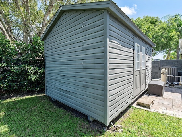 view of outbuilding with cooling unit, fence, and an outdoor structure